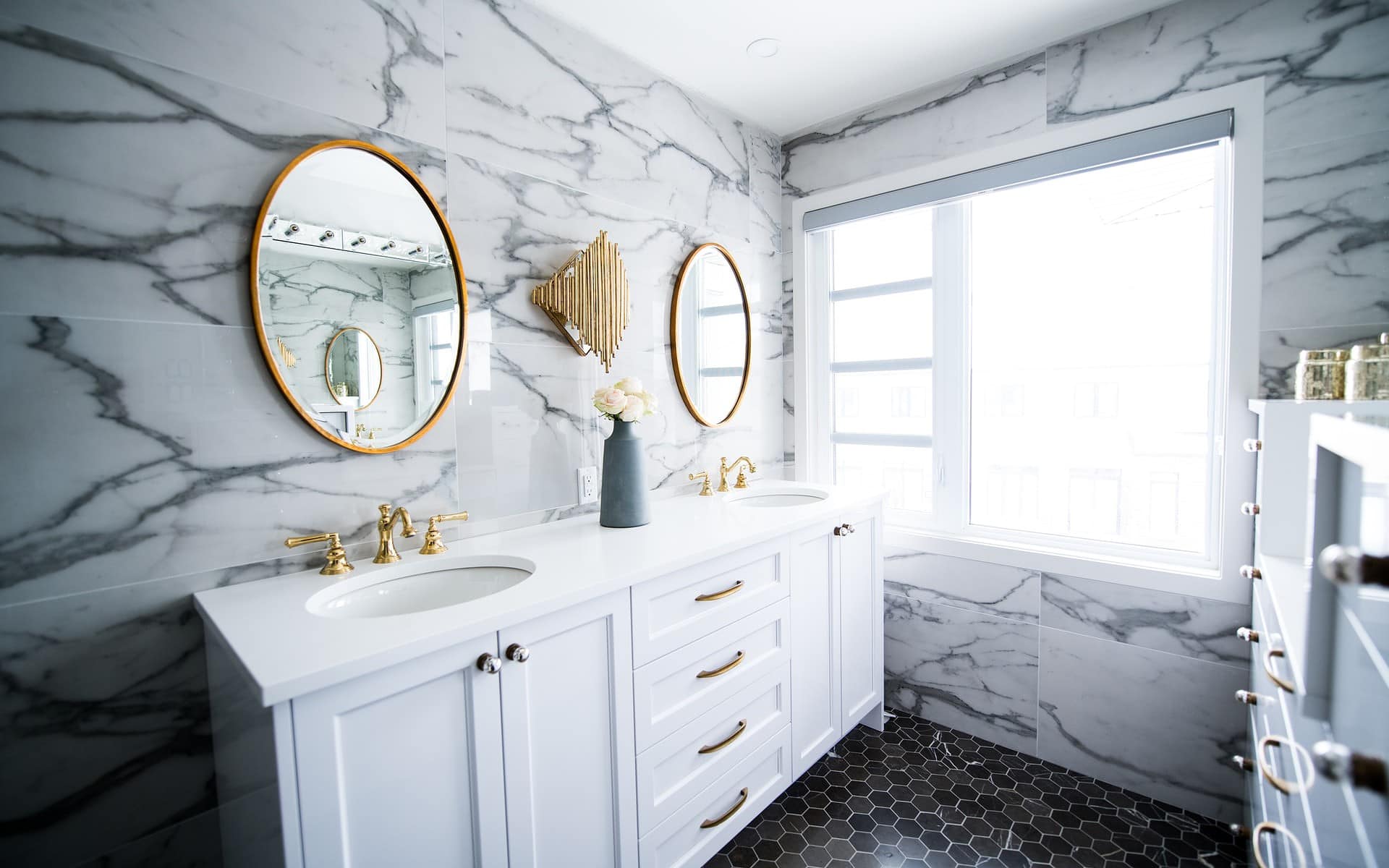 Interior Design - white marble covered bathroom with white vanity and golden acents