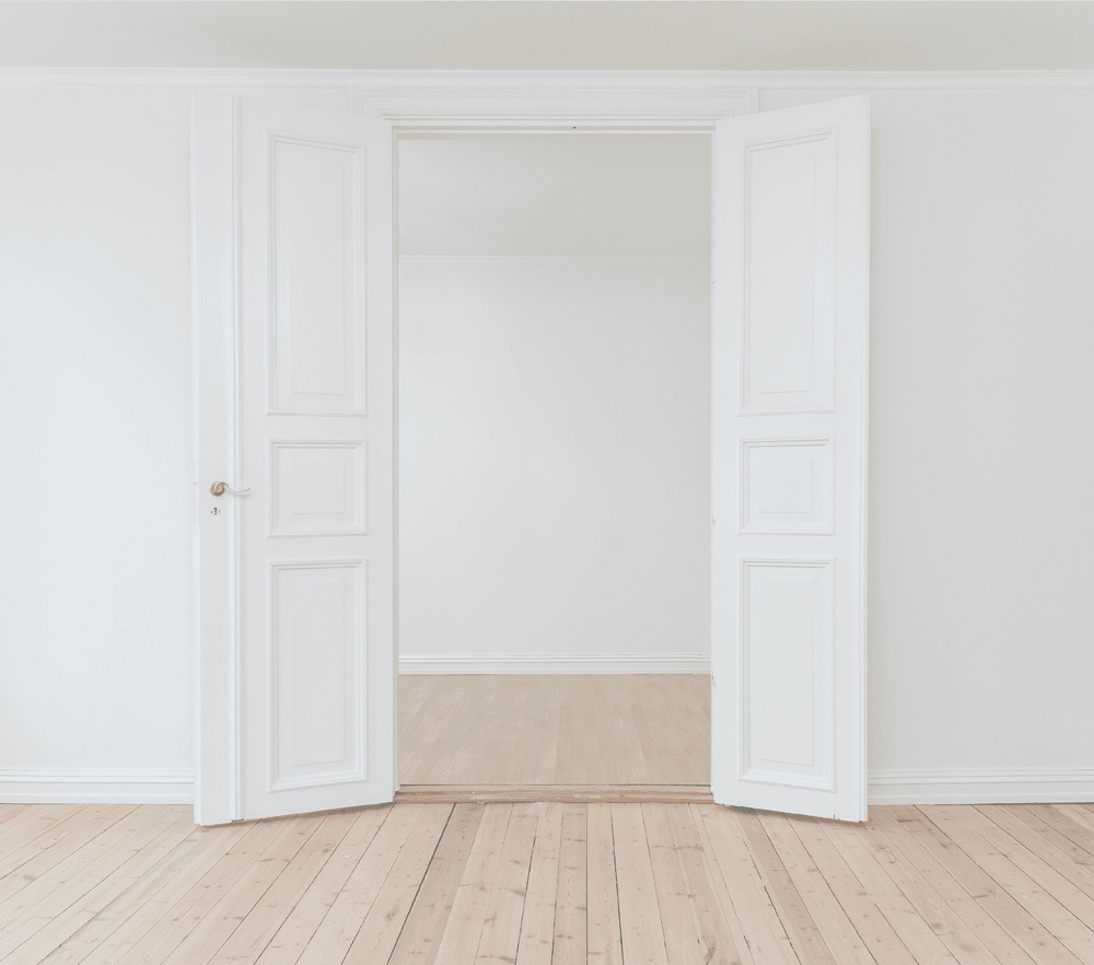 white wall with double white doors opening